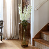 Hoge glazen vaas met planten