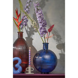 Blauwe bolle glazen vaas met bloemen