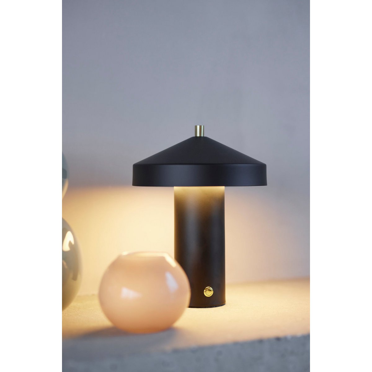 Zwarte design tafellamp staat aan