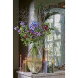 Hoge glazen vaas met bloemen