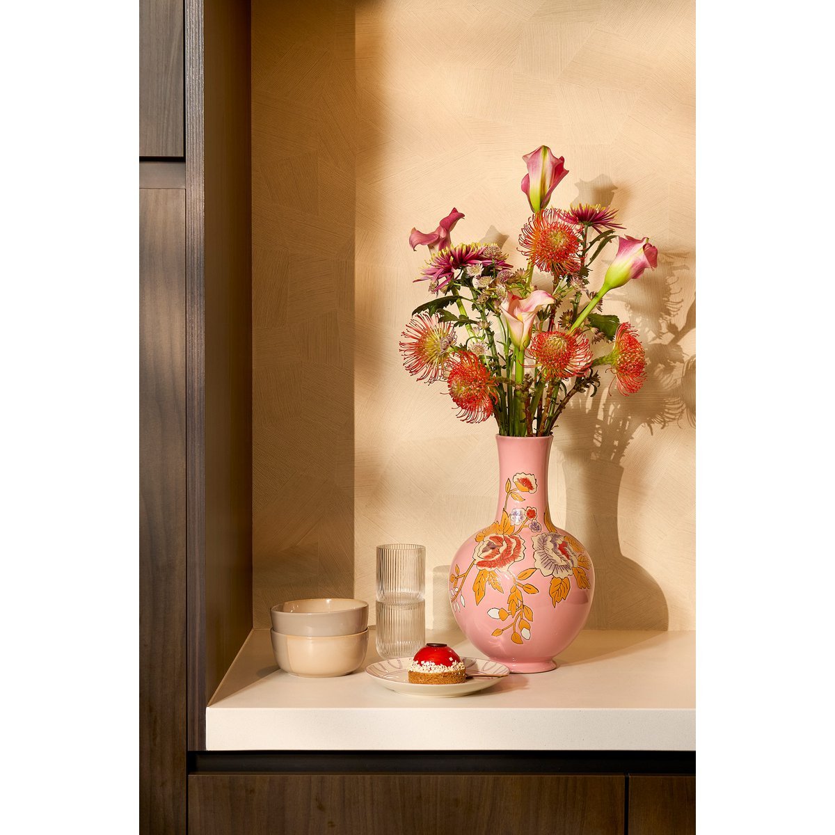 Roze vaas met bloemen in keuken