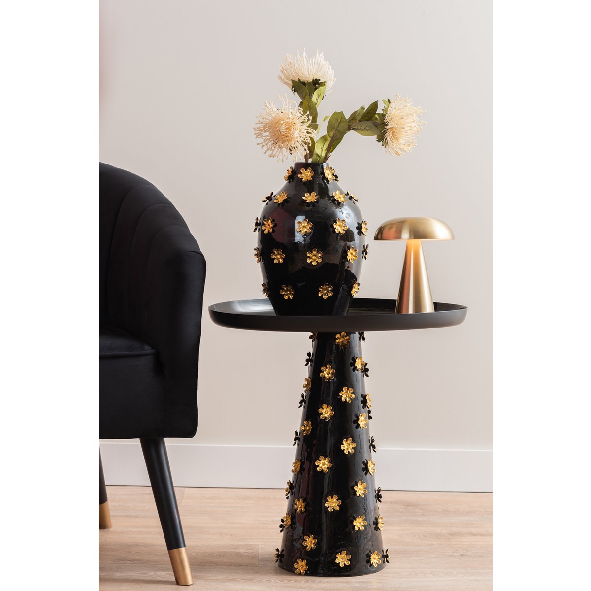 Zwarte vaas gouden bloemen op matching tafel