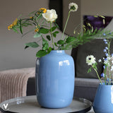 Blauwe glazen vaas op tafel