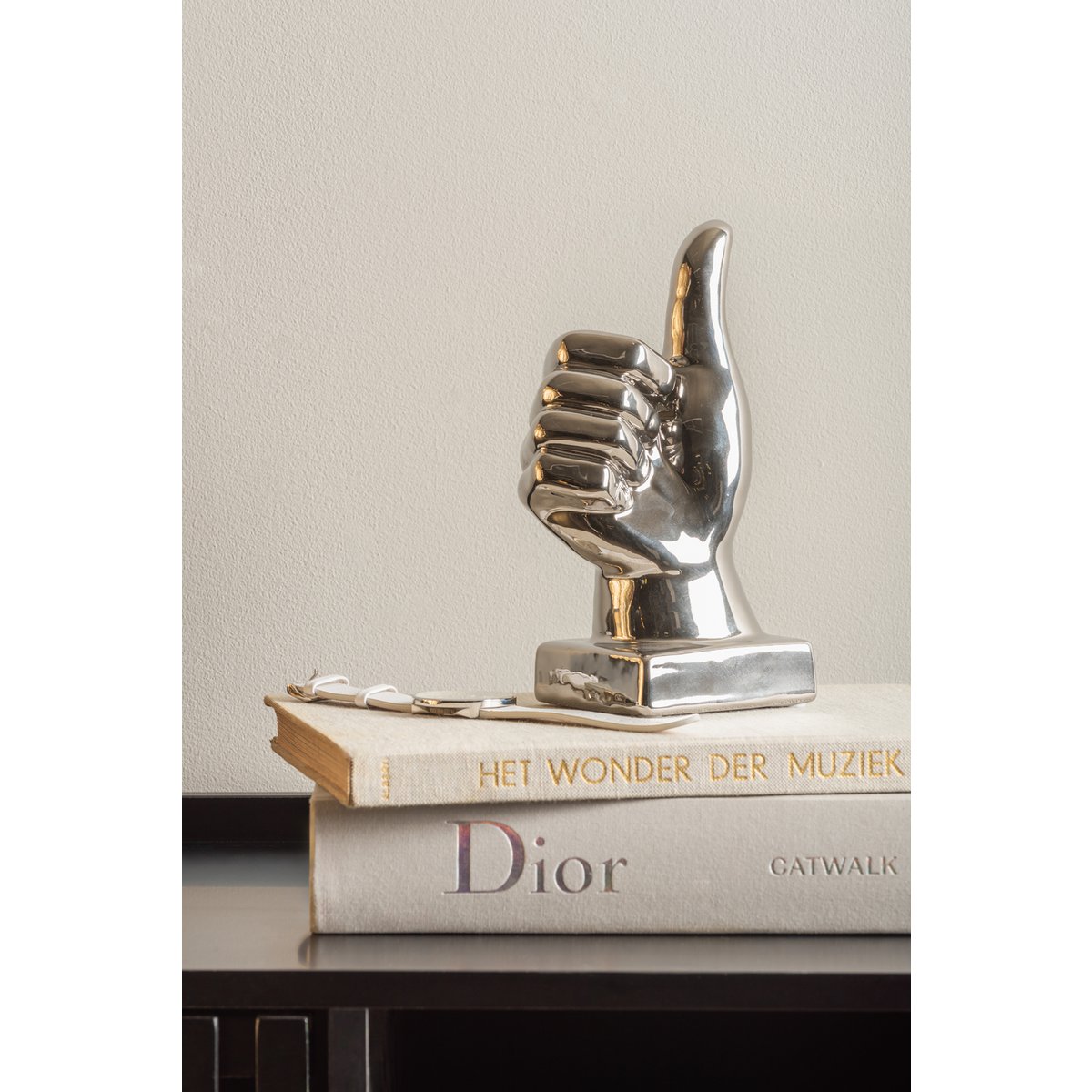 Duim beeld zilver op boeken